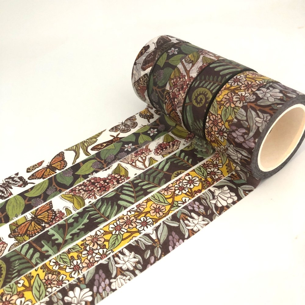 Custom washi tape rolls with detailed CMYK and foil printed designs featuring intricate artwork